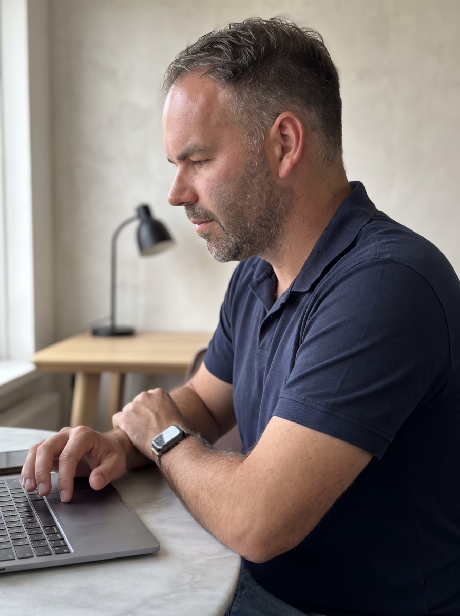Martijn Scholten werkt aan een website achter zijn laptop